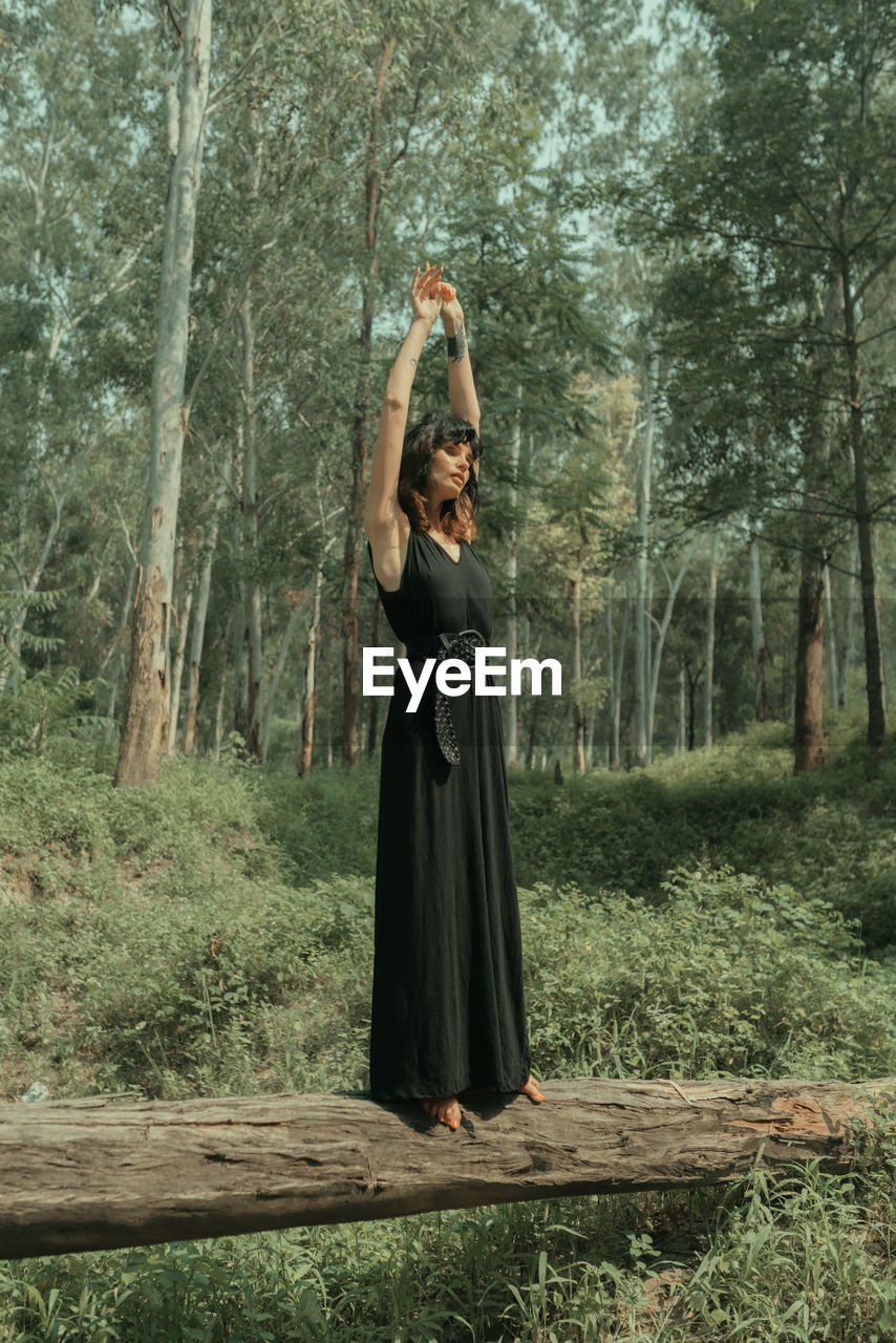 WOMAN STANDING IN FOREST