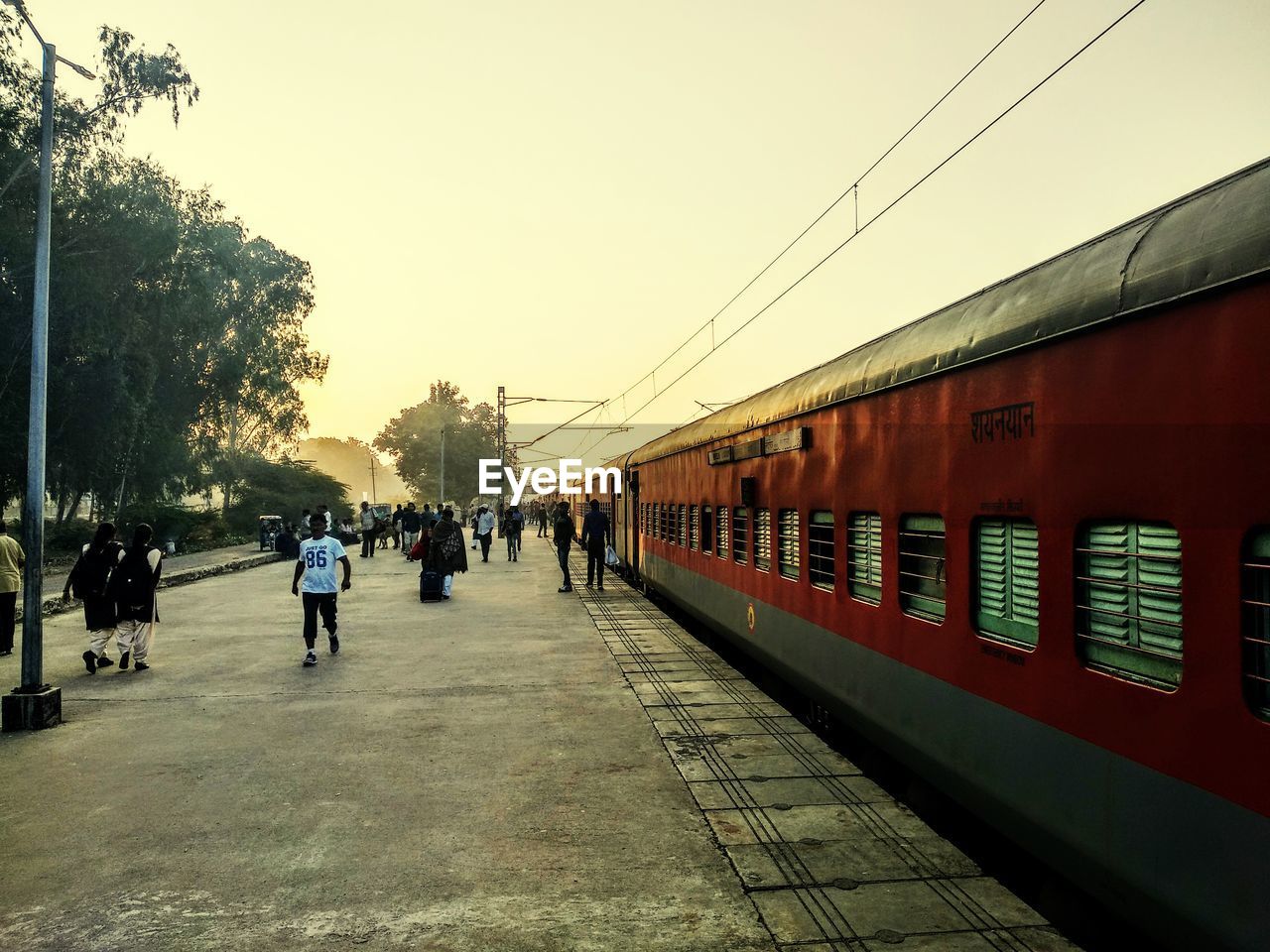 PEOPLE AT RAILROAD STATION AGAINST CLEAR SKY