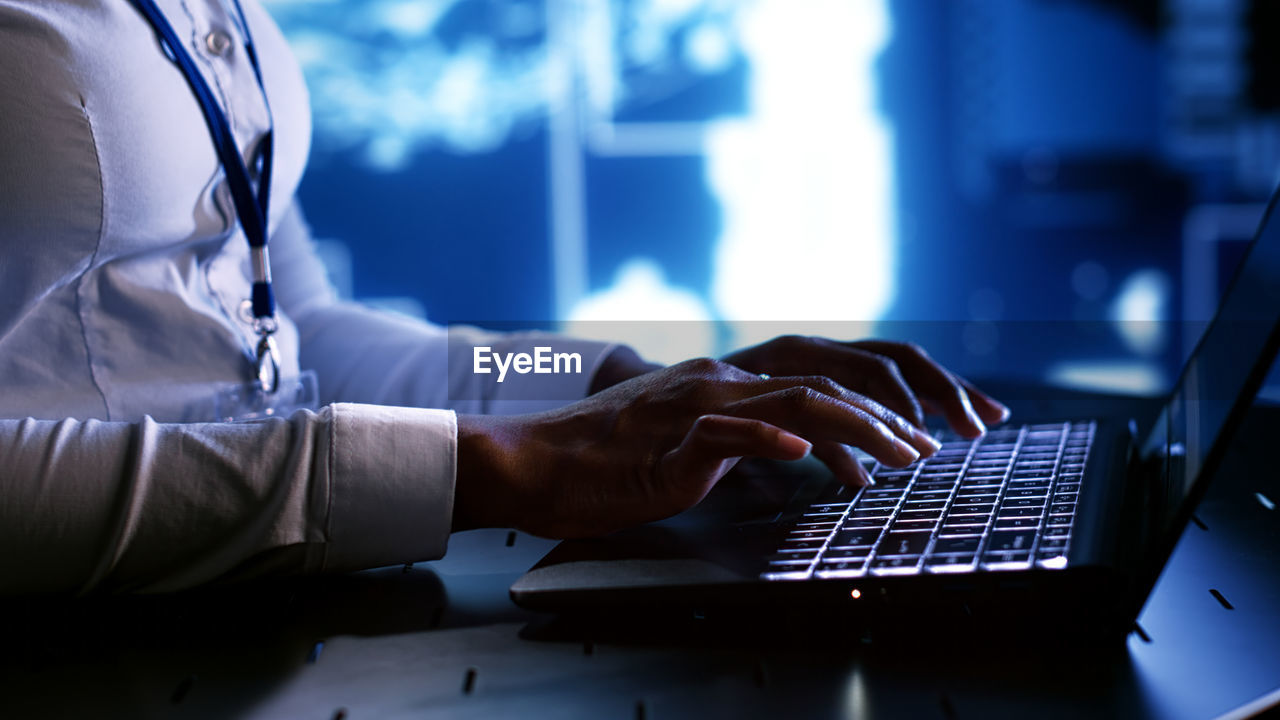 midsection of woman using laptop on table