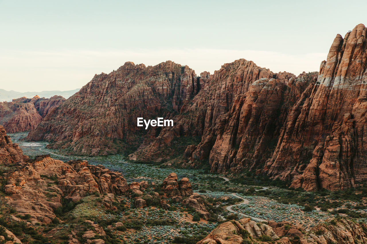 Red cliffs of snow canyon state park with green valley road beneath