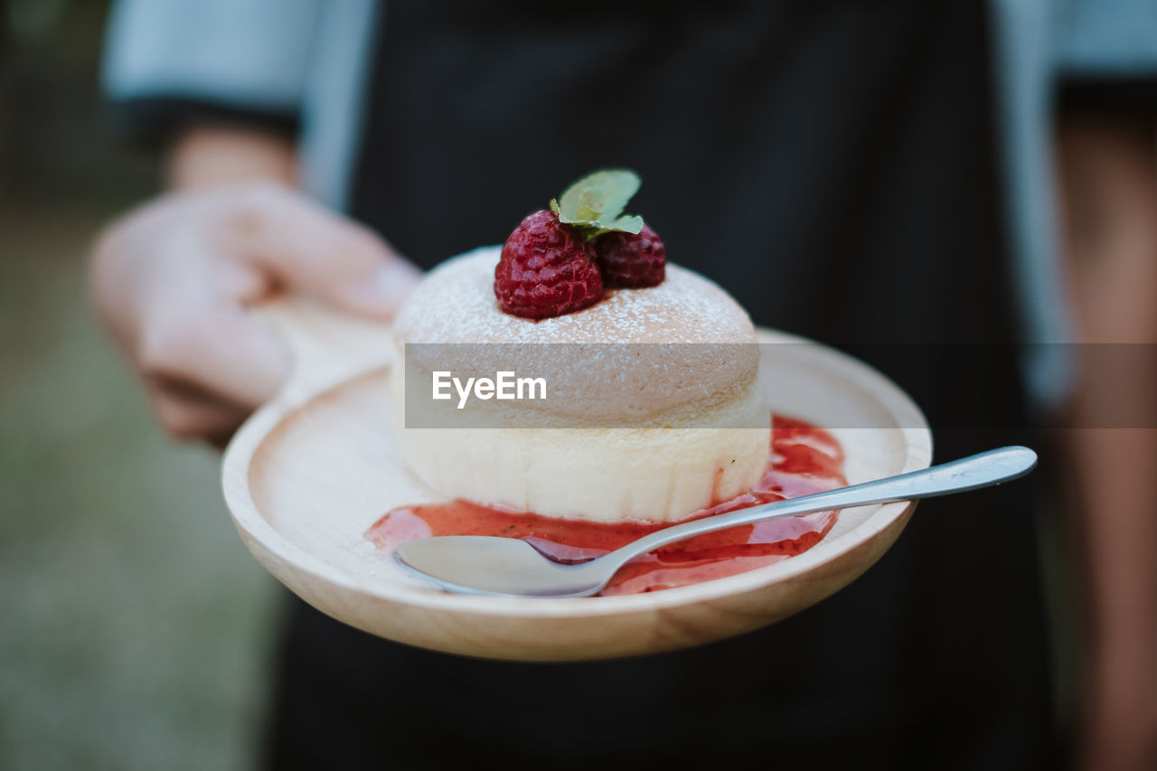 CLOSE-UP OF HAND HOLDING ICE CREAM WITH CAKE