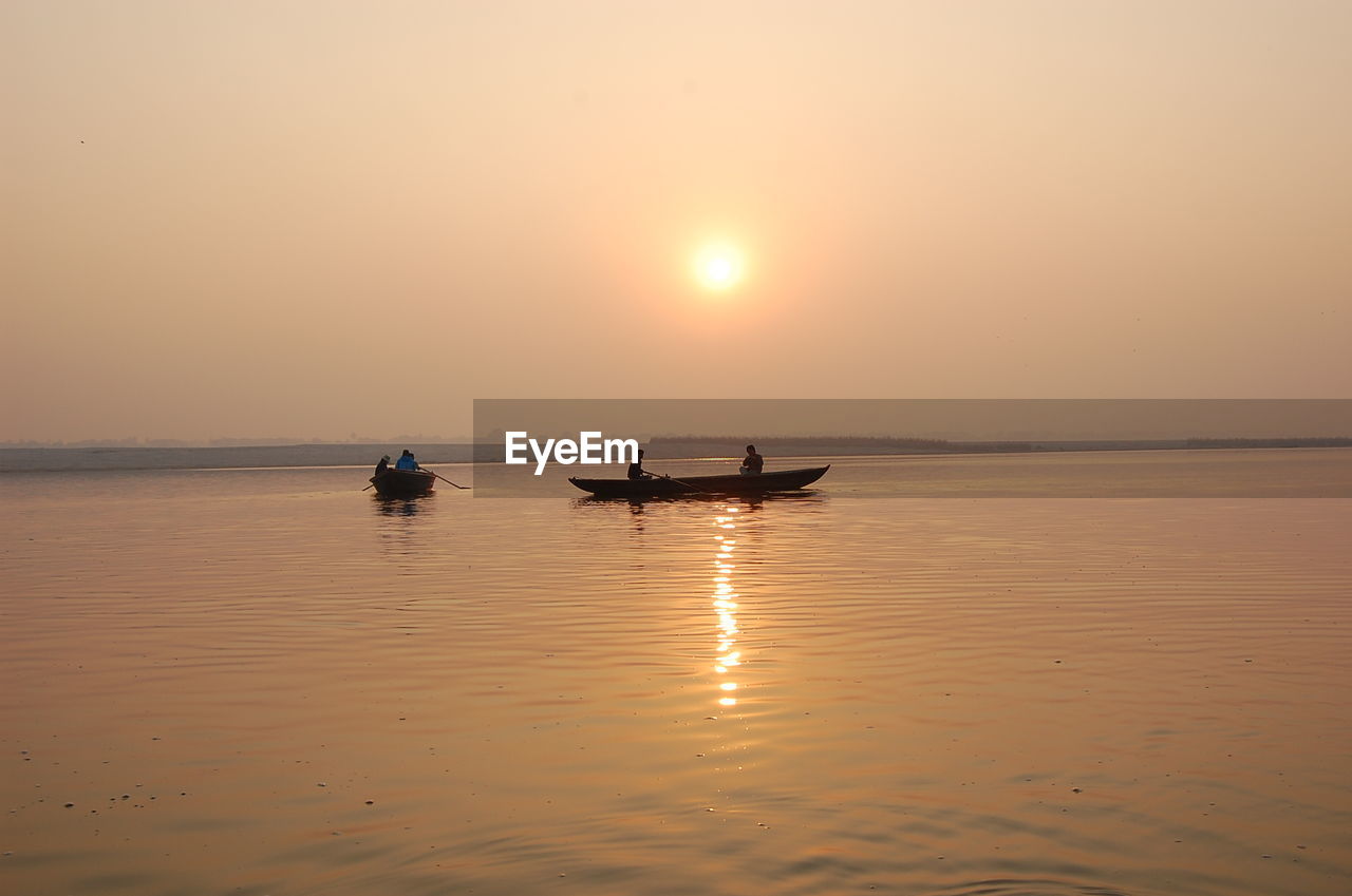 BOAT ON SEA AGAINST SKY DURING SUNSET