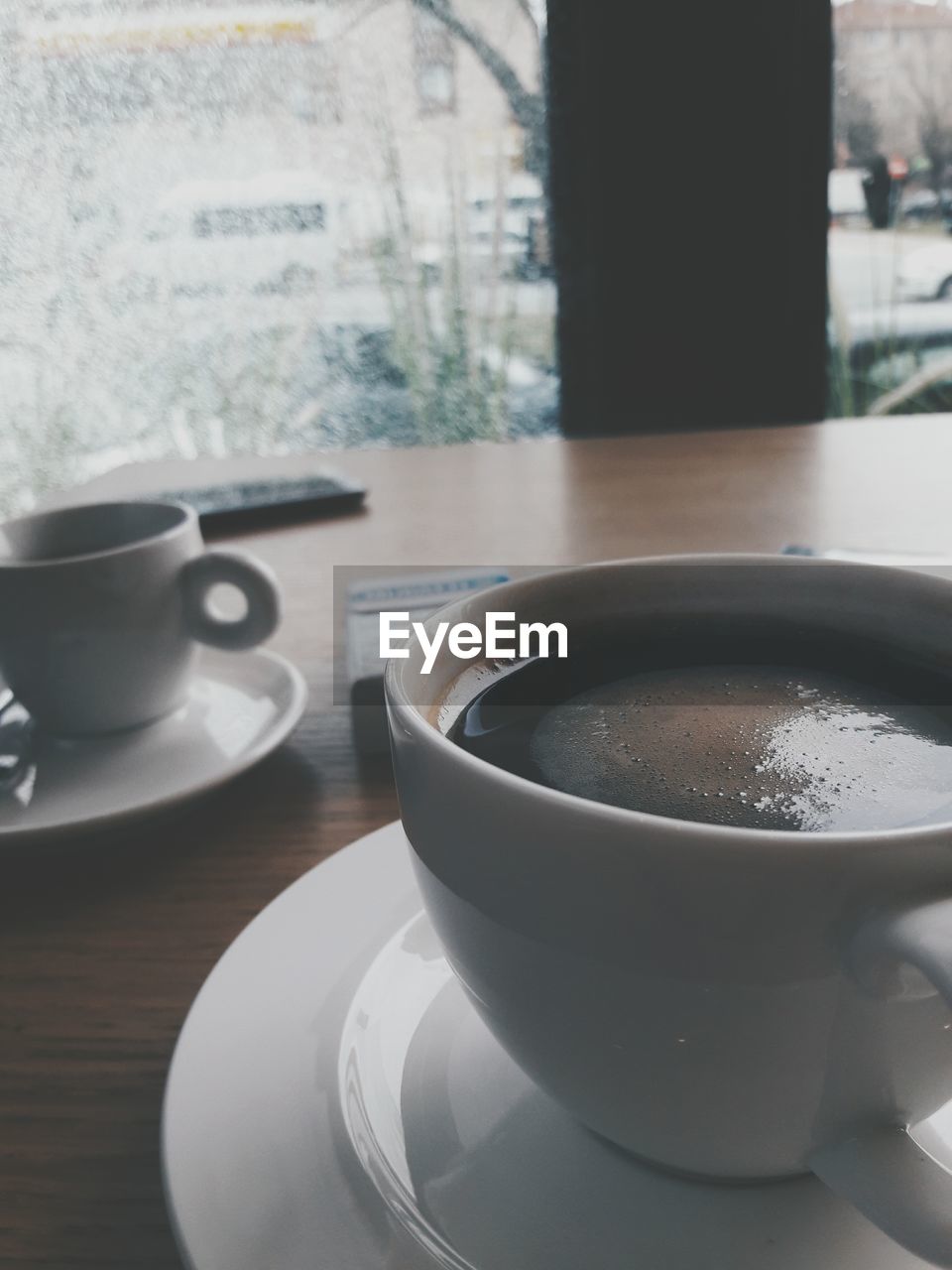 CLOSE-UP OF COFFEE CUP AND TABLE