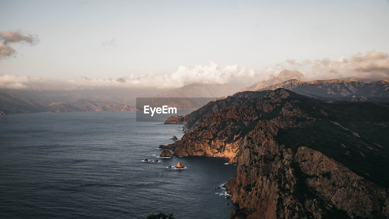 SCENIC VIEW OF SEA BY MOUNTAINS AGAINST SKY