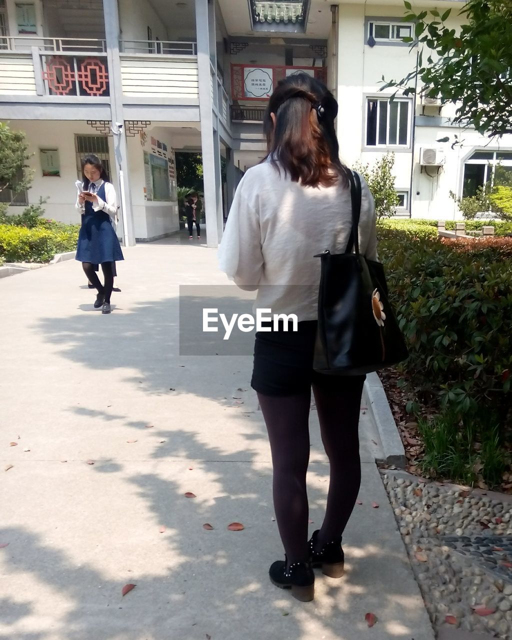 REAR VIEW OF TWO WOMEN WALKING ON FLOOR