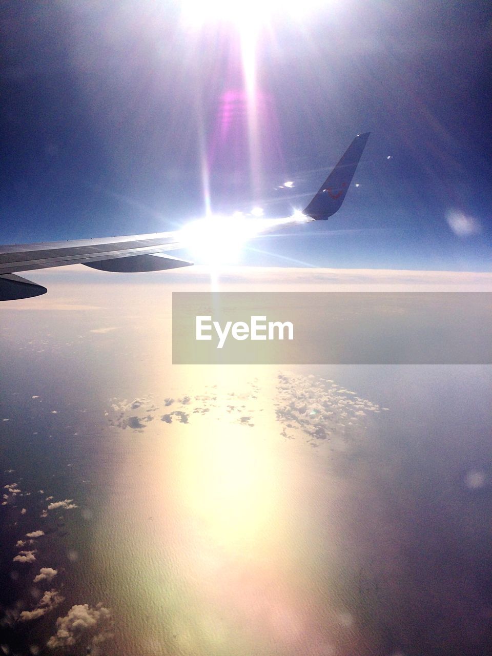 AIRPLANE FLYING OVER SEA AGAINST SKY