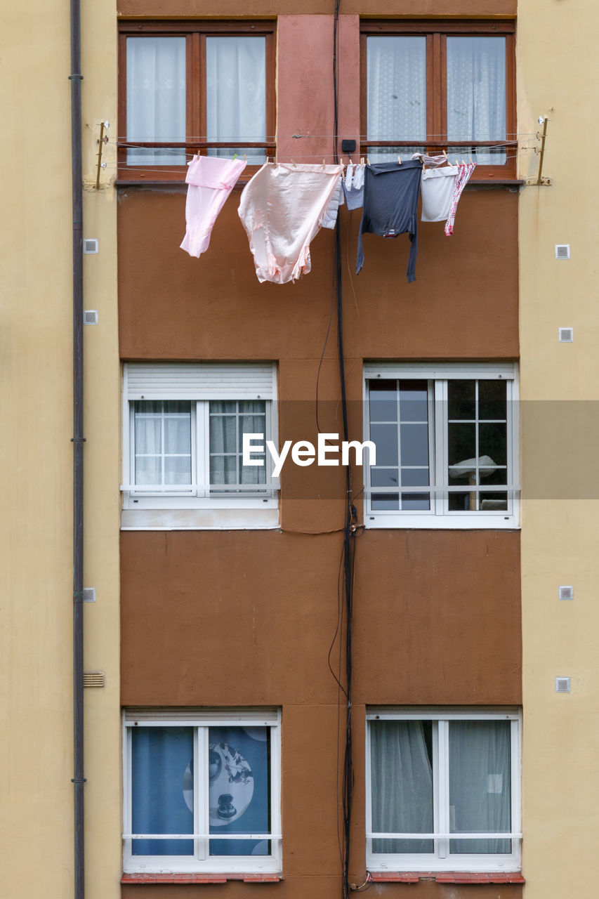Front of a residential building with clothes dying on a rope.