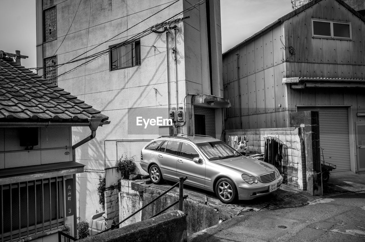 CARS PARKED ON STREET AMIDST BUILDINGS