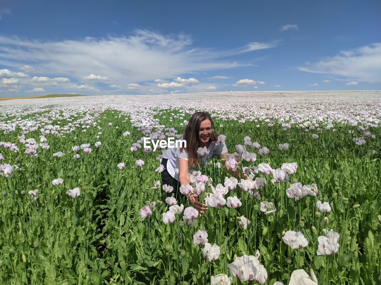 WOMAN WITH FLOWERS ON FIELD