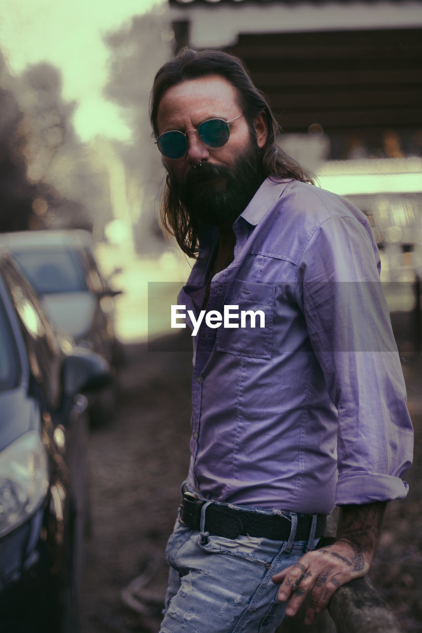 portrait of young man wearing sunglasses while standing outdoors