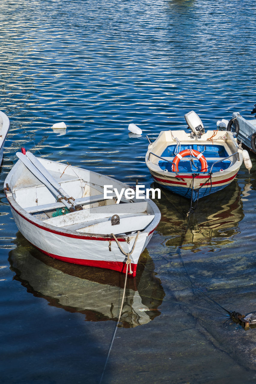 HIGH ANGLE VIEW OF FISHING BOAT MOORED AT LAKE