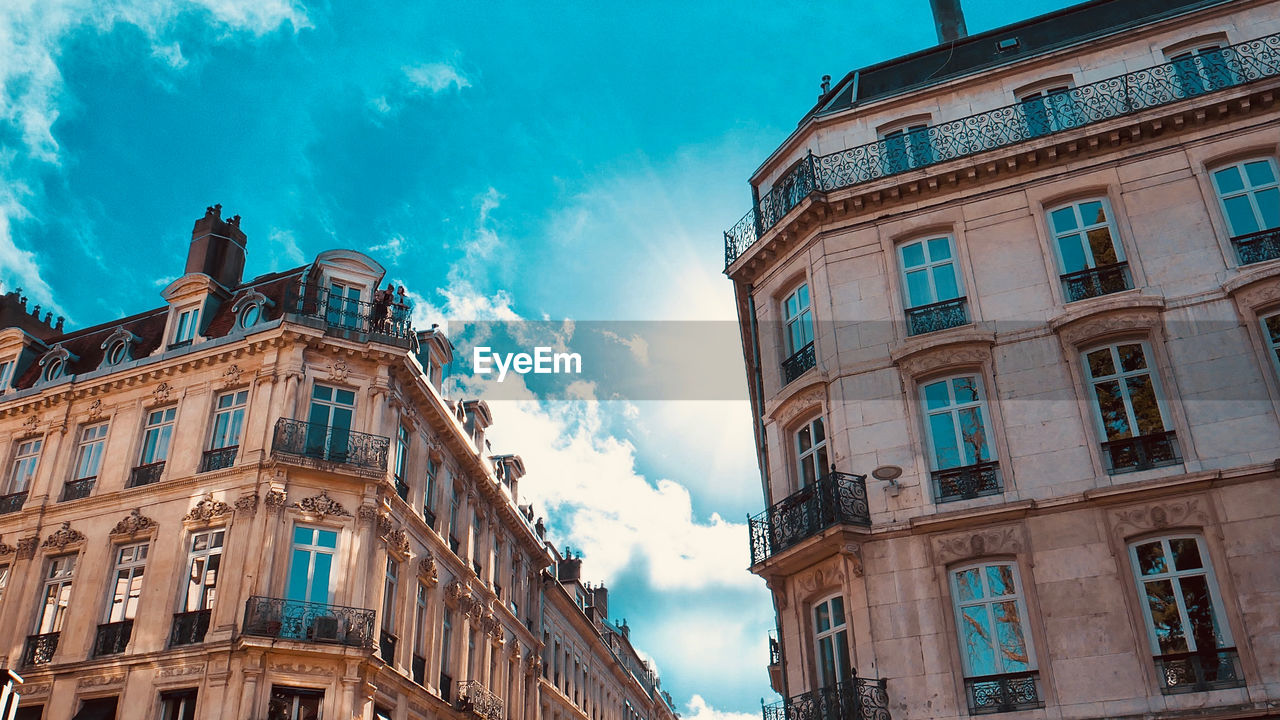 Low angle view of buildings against cloudy sky