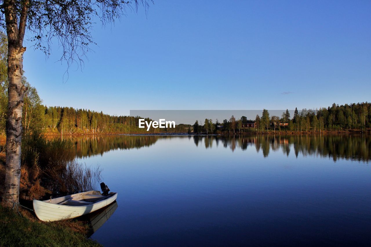 Scenic view of lake against clear blue sky