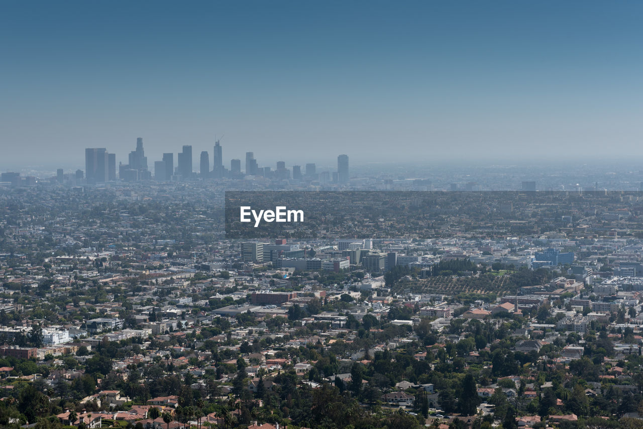 Aerial view of buildings in city against clear sky