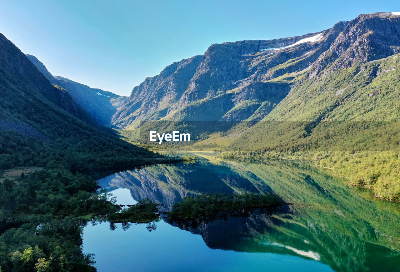 Scenic view of lake and mountains against clear sky