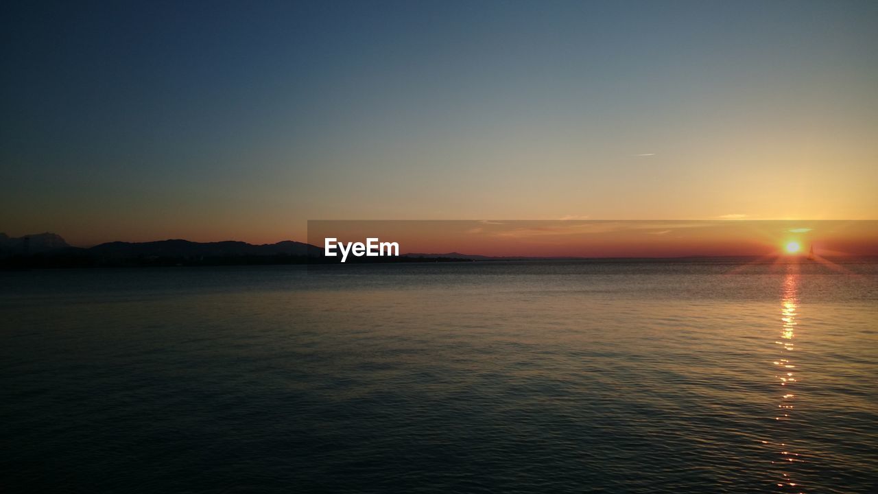 SCENIC VIEW OF SEA AT SUNSET