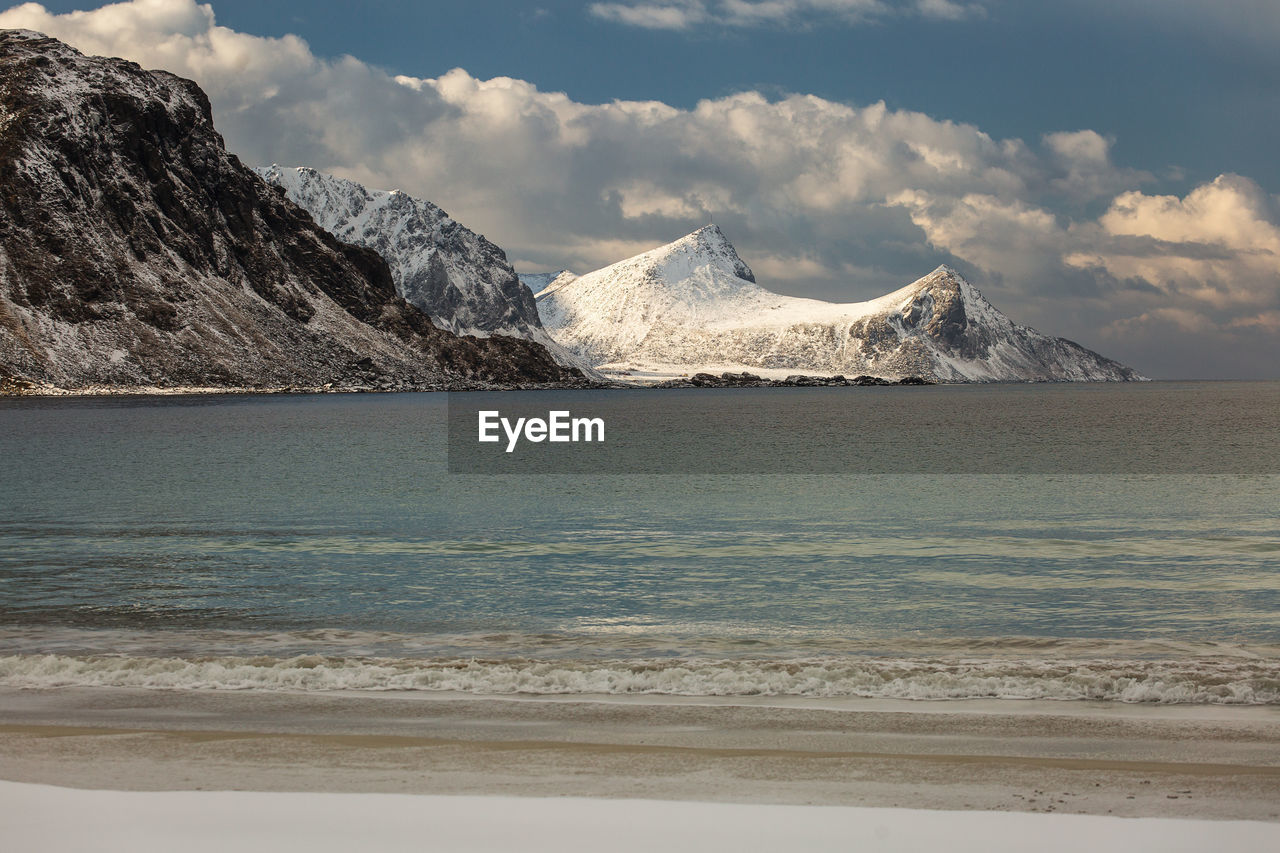 Scenic view of sea and mountains against sky