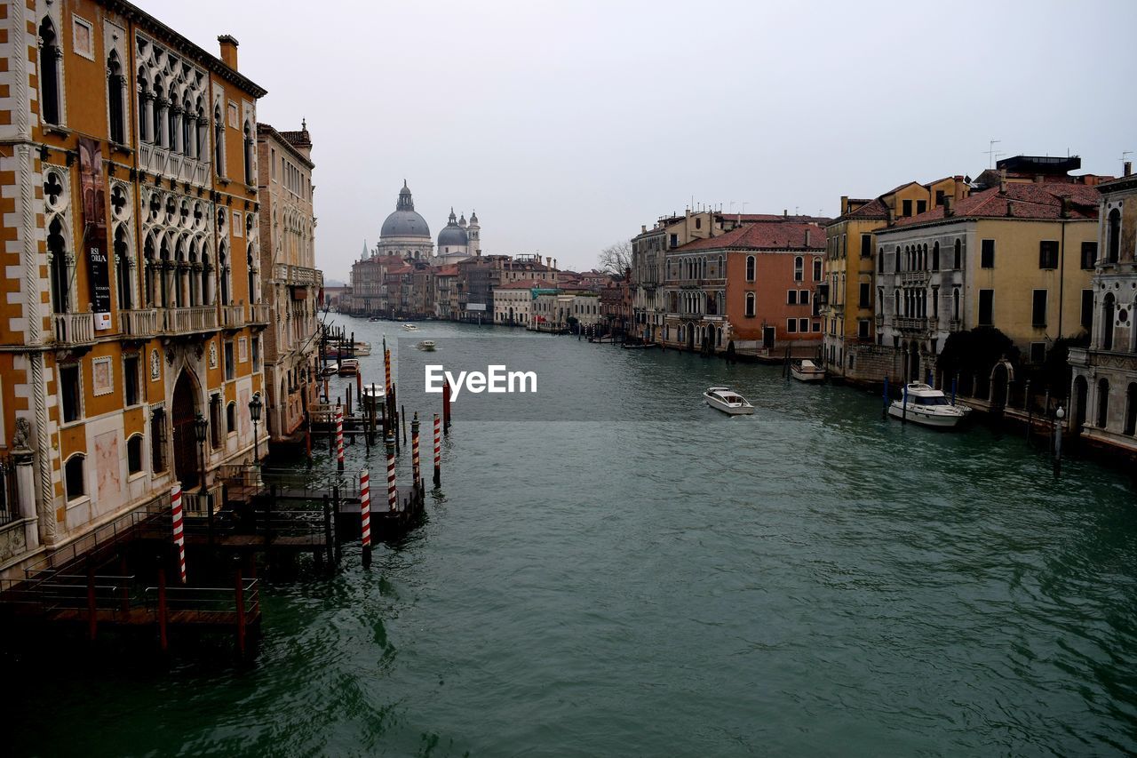 Boats in canal along buildings