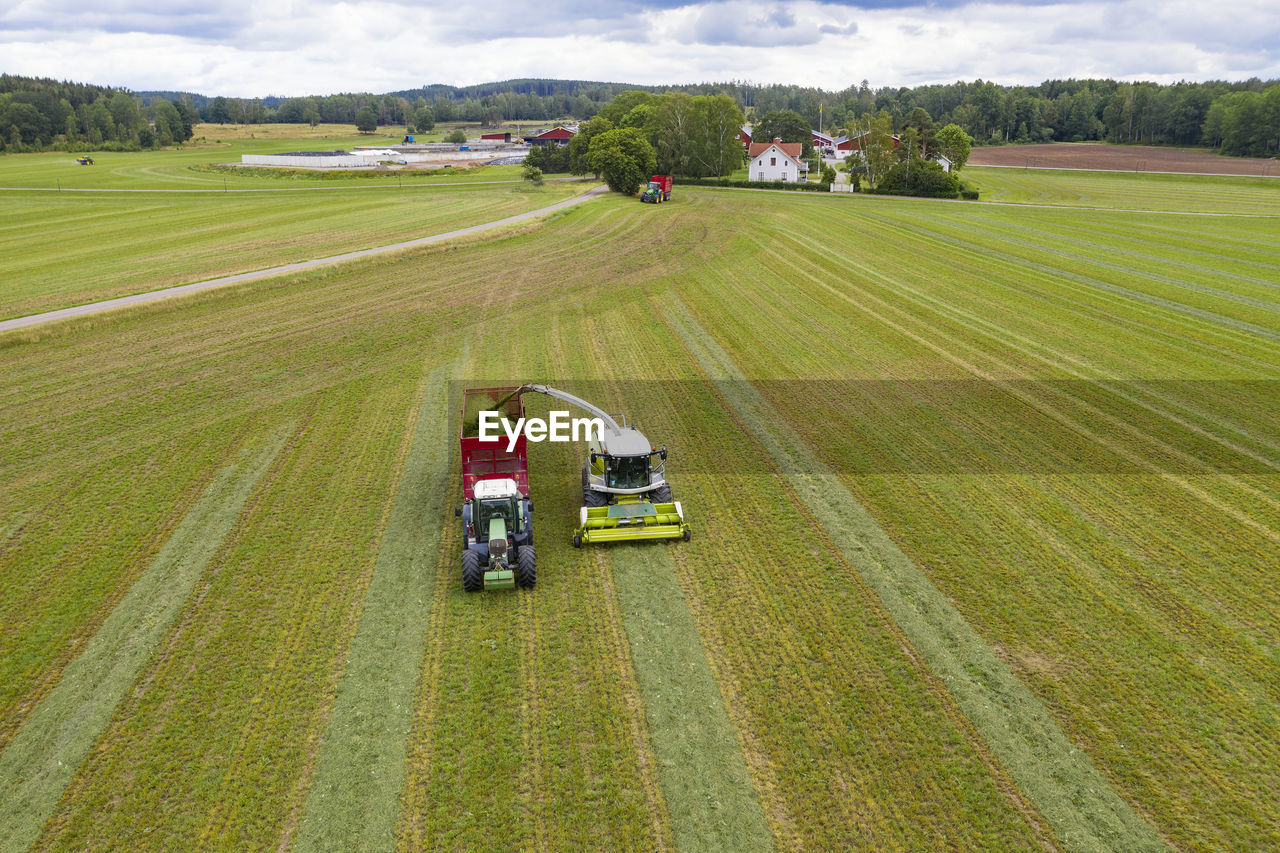 Harvester and tractor on field