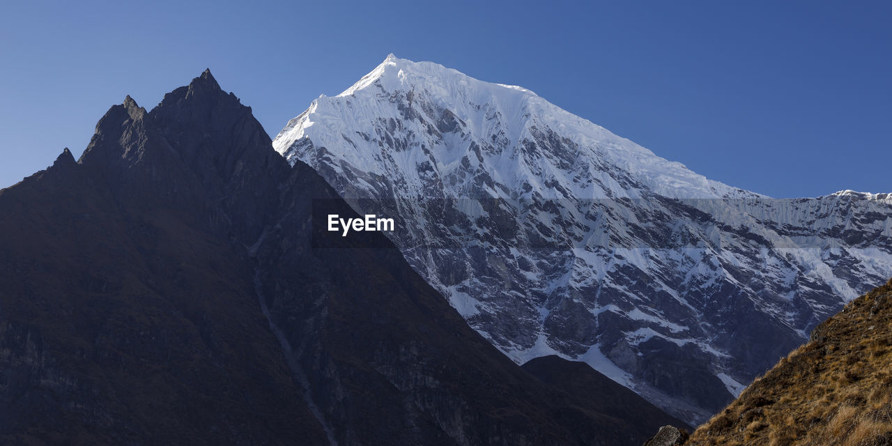 Scenic view of snowcapped mountains against clear sky