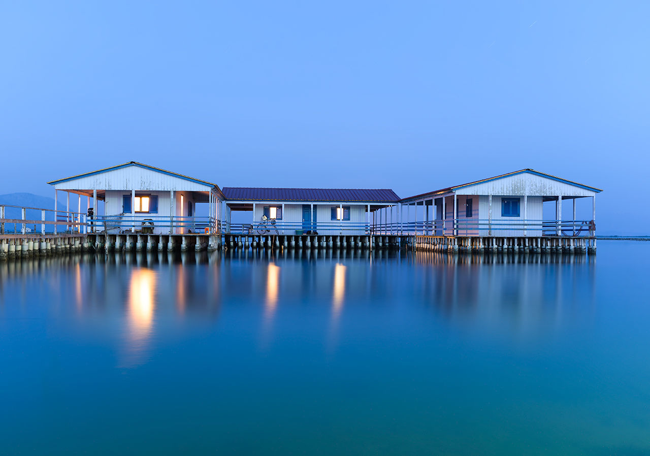 Built structure on pier by sea against clear sky