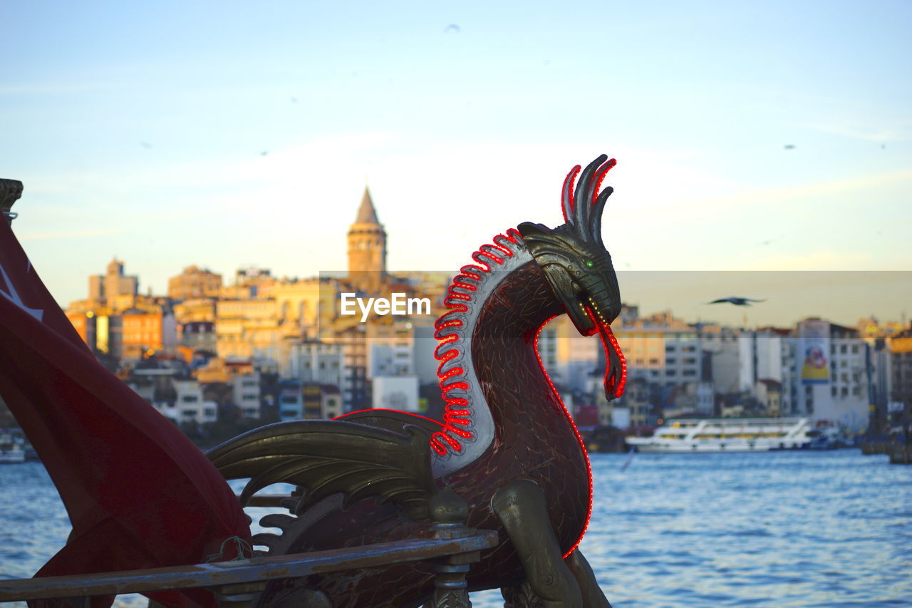 VIEW OF STATUE BY RIVER IN CITY