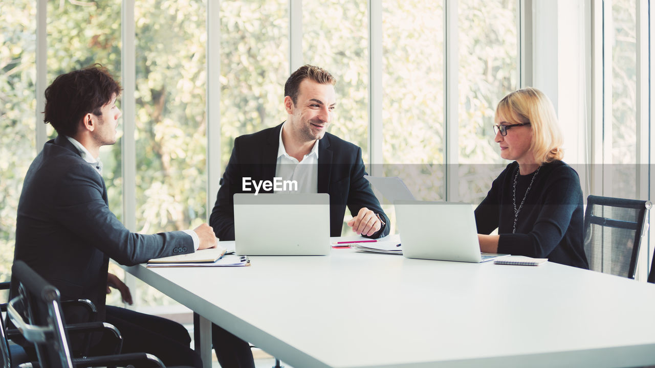 Business people discussing while sitting at table