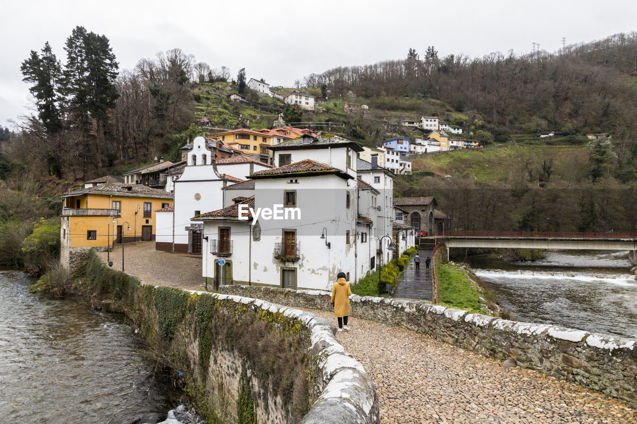 HOUSES BY RIVER AGAINST BUILDINGS