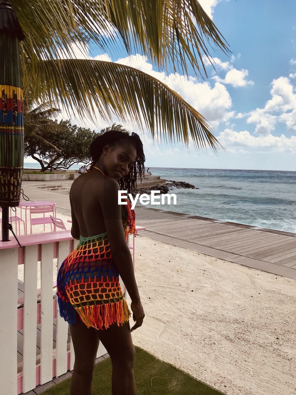 Woman standing at beach against sky