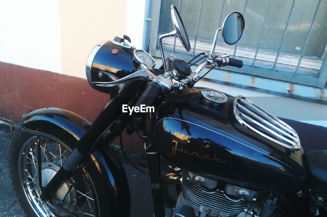 CLOSE-UP OF BICYCLE PARKED AGAINST BLURRED BACKGROUND