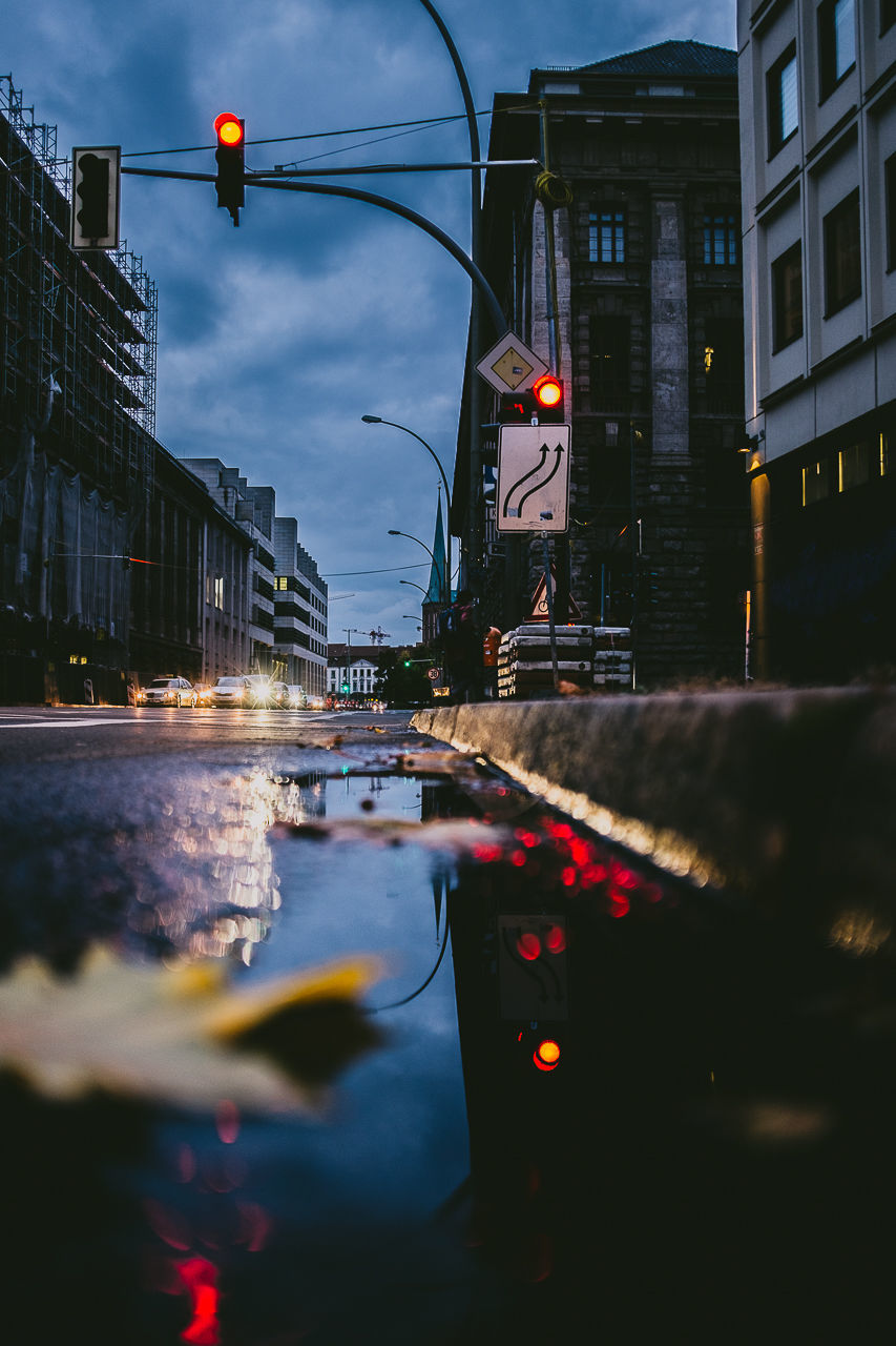 ILLUMINATED CITY STREET BY WATER