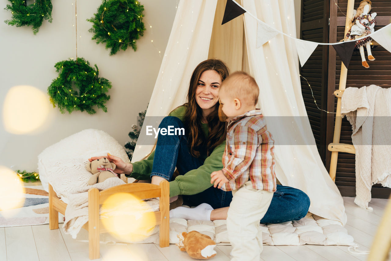 Mom plays with the child in a teddy bear in the children's room.