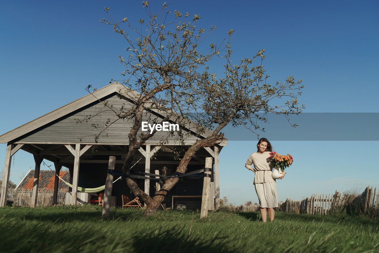 Woman standing on field against sky