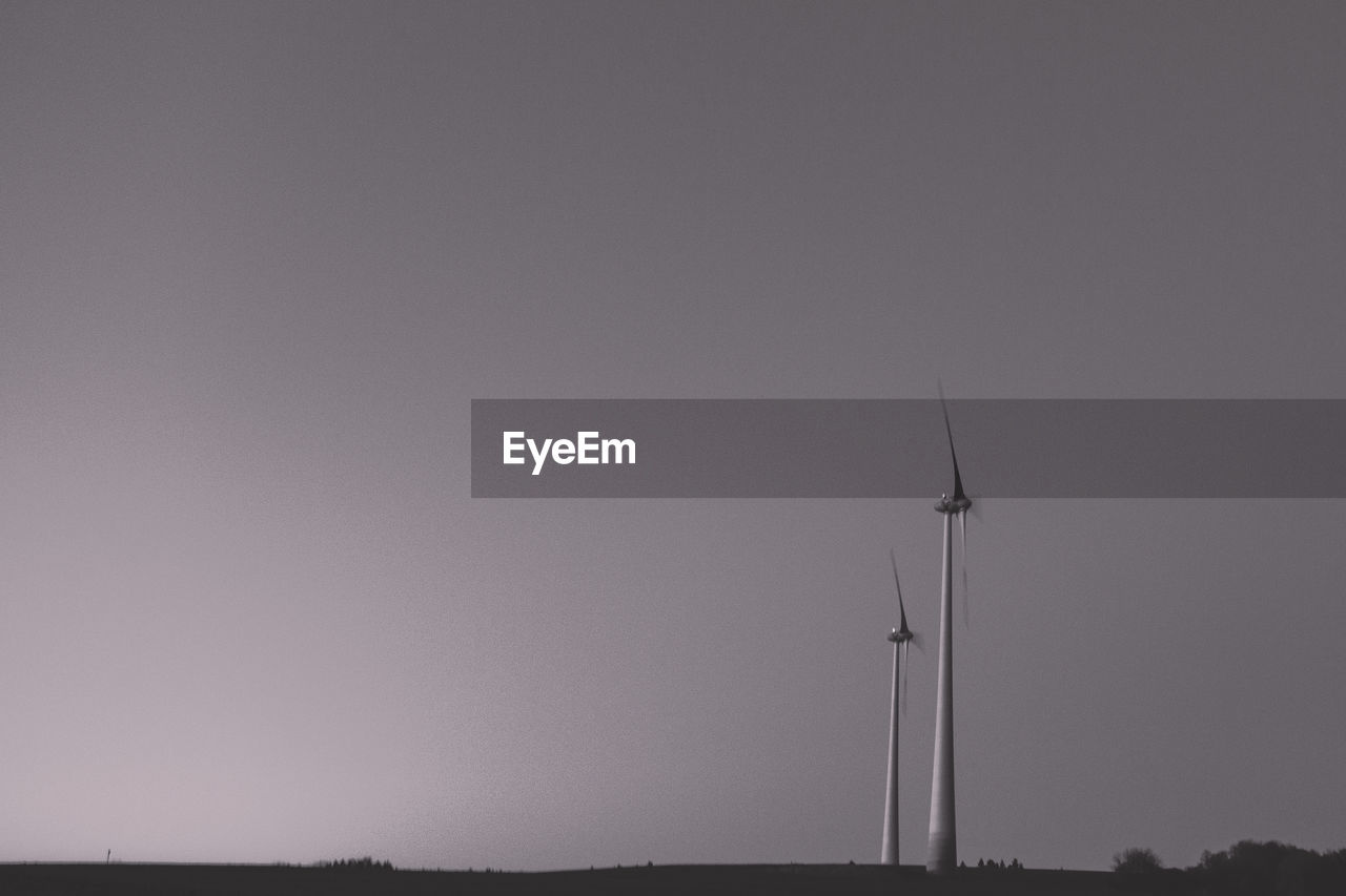 Scenic view of wind turbines against clear sky