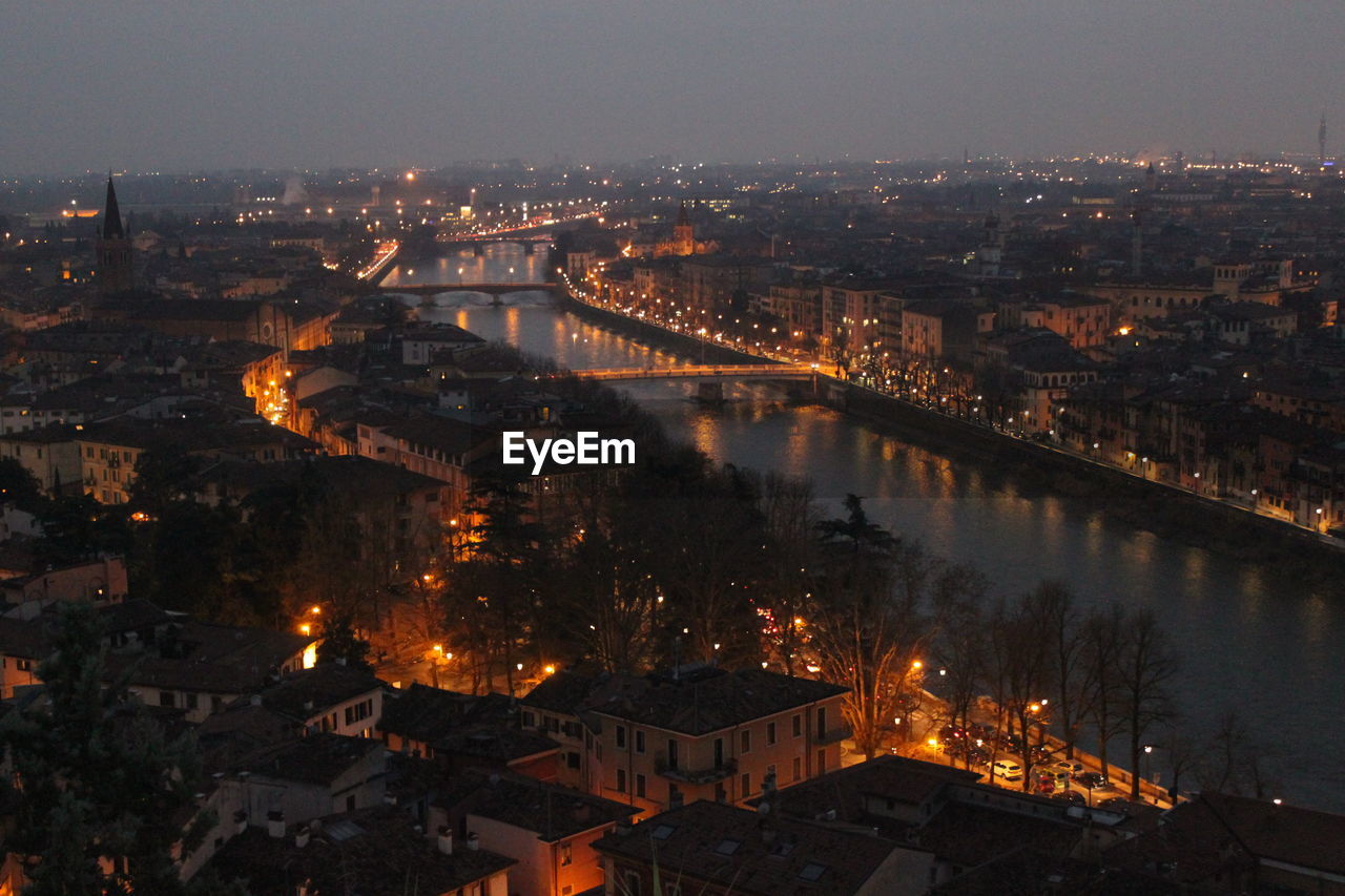 Aerial view of illuminated bridge over river in city