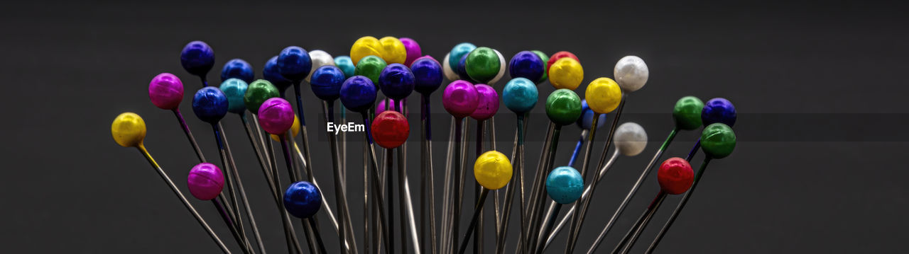 multi colored, studio shot, variation, large group of objects, black background, indoors, flower, no people, macro photography, yellow, purple, close-up, still life, panoramic, creativity, abundance, vibrant color