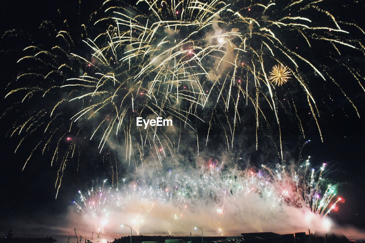 Low angle view of firework display at night