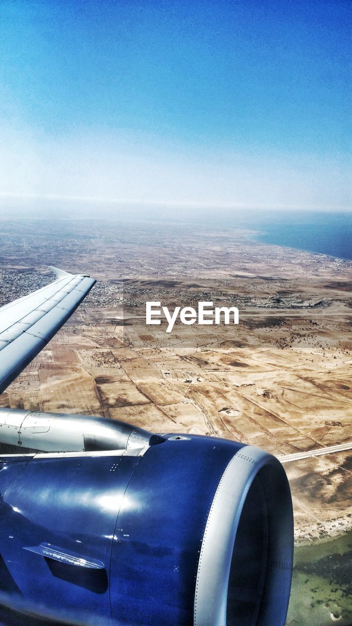 CLOSE-UP OF AIRPLANE WING AGAINST CLEAR SKY