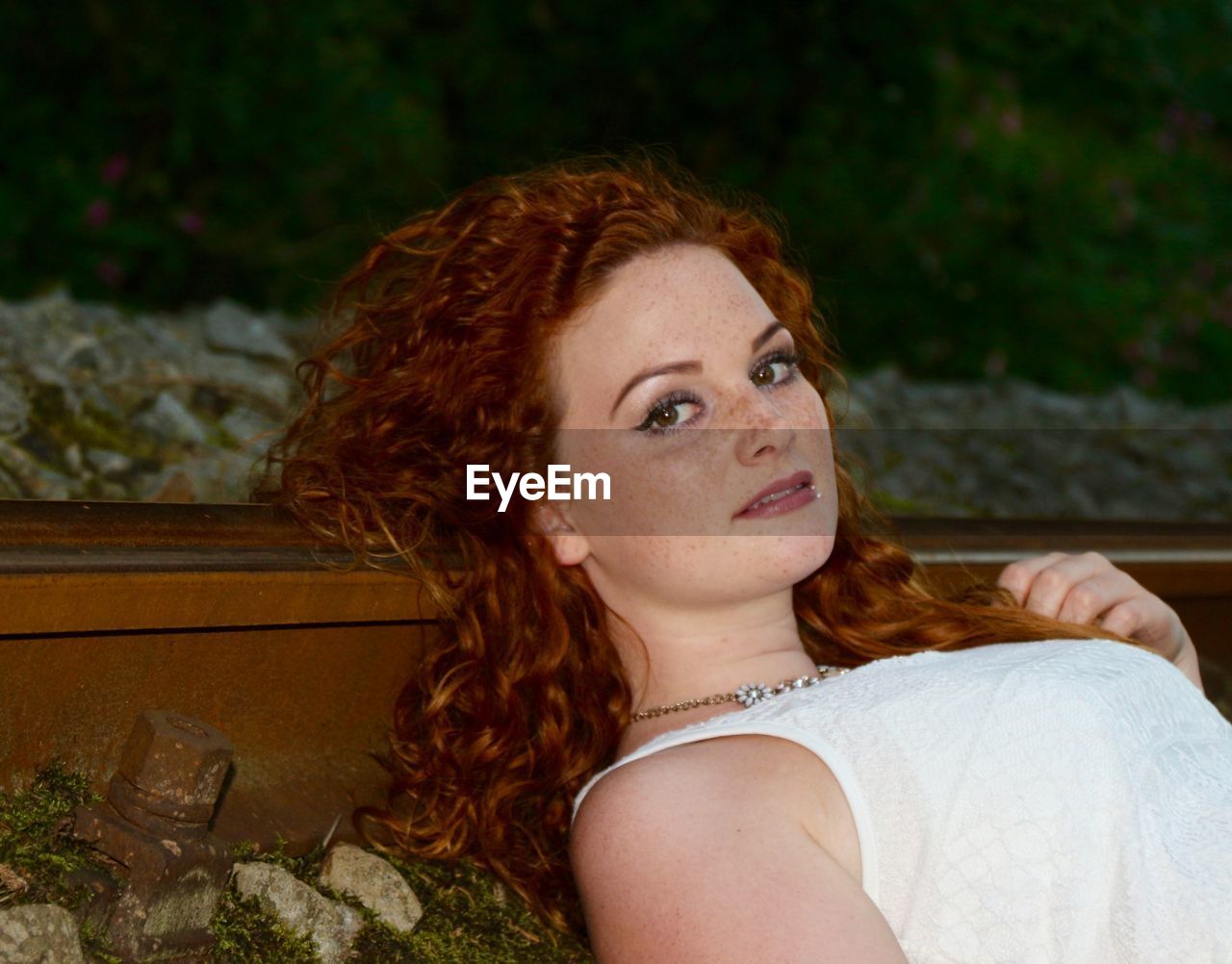 Portrait of woman lying on railroad track