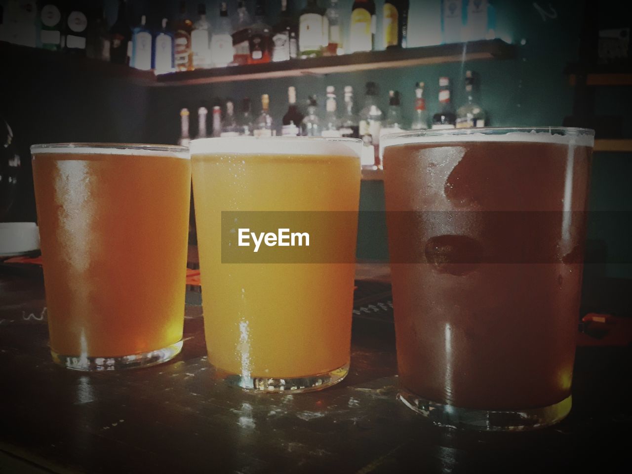 CLOSE-UP OF BEER GLASS ON BAR COUNTER