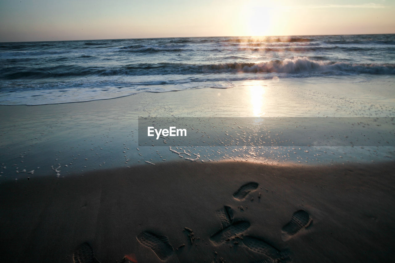 Scenic view of beach against sky during sunset