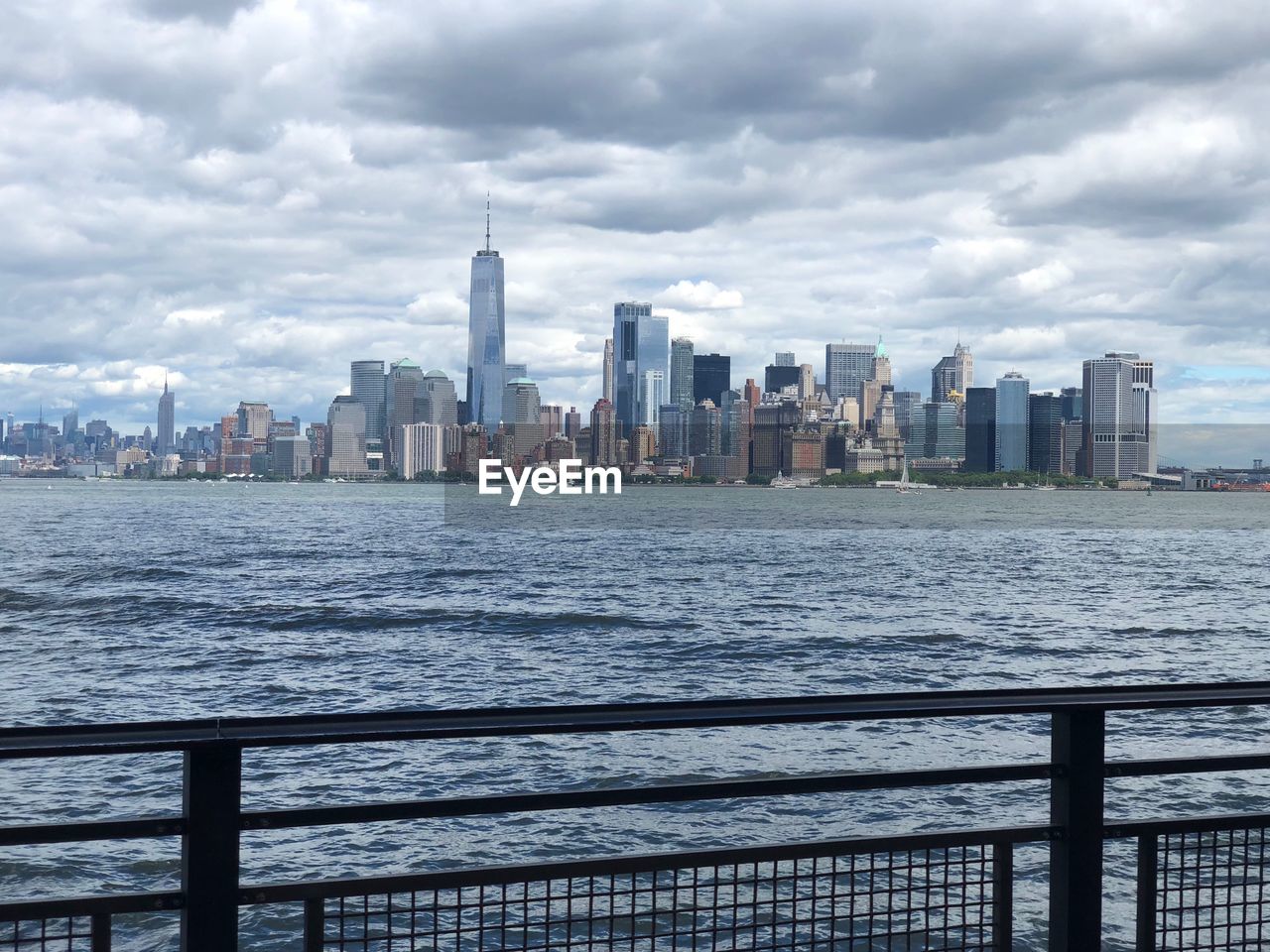 View of buildings at waterfront against cloudy sky