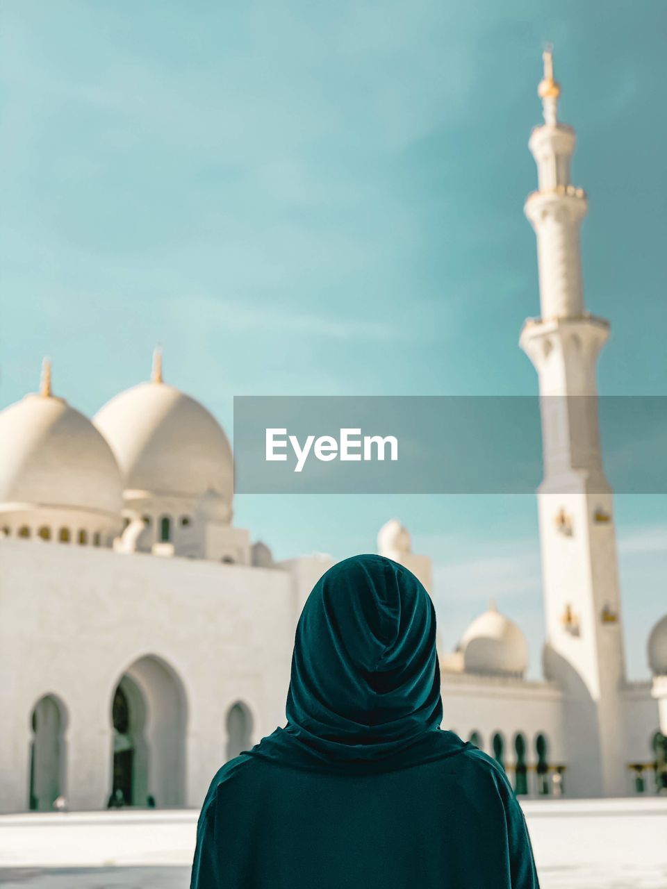 Rear view of woman looking at mosque against sky