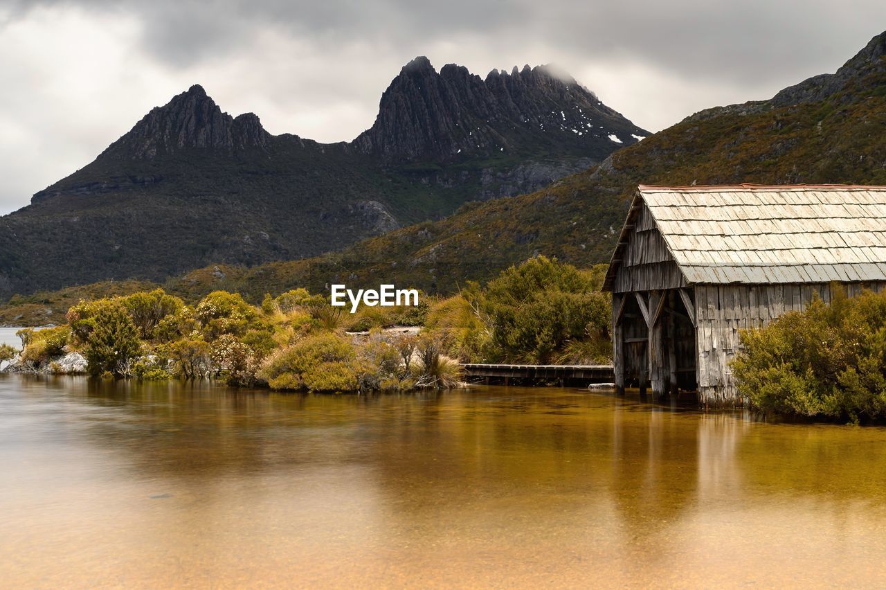 Scenic view of lake by mountains against sky