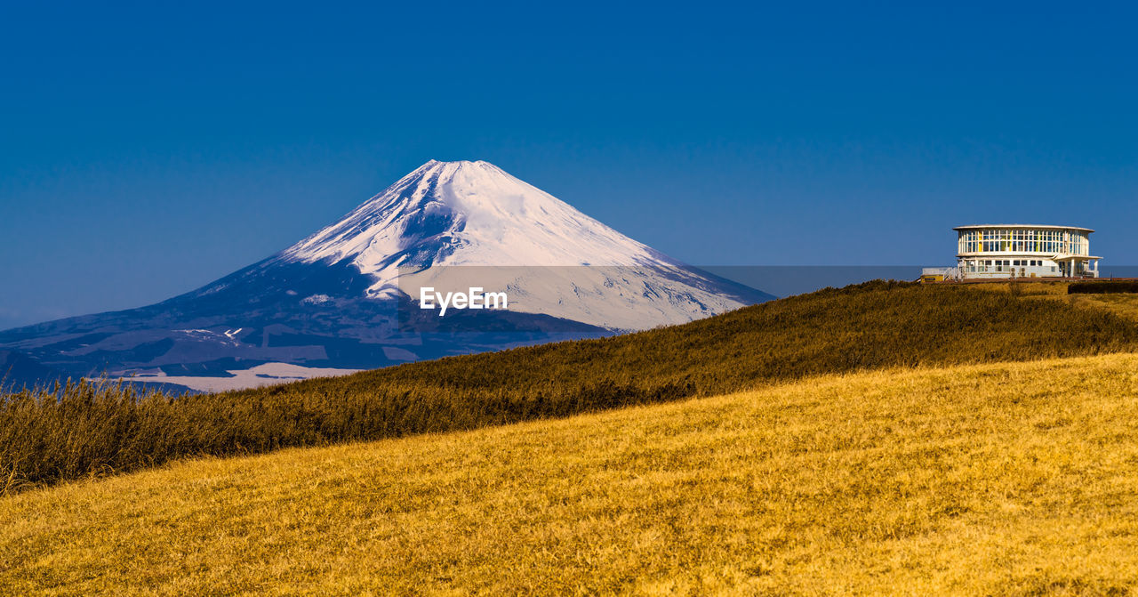 Summit of mountain ridge pass with fields of grass and view of mt. fuji.