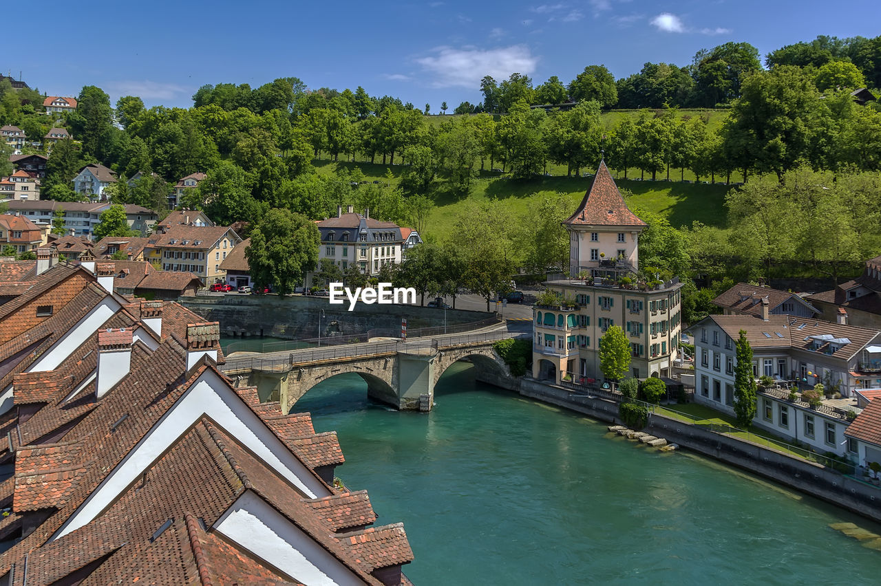 BRIDGE OVER RIVER AMIDST BUILDINGS