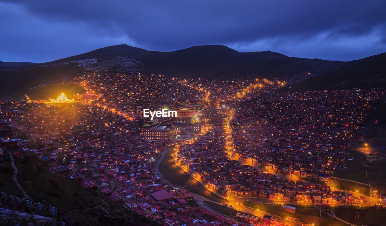 Illuminated cityscape against sky at night