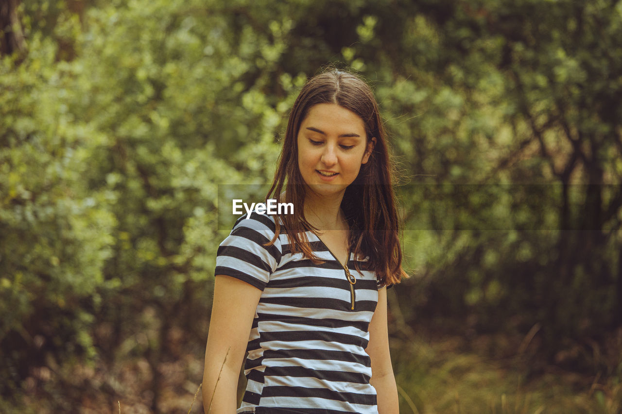 Young woman standing in forest