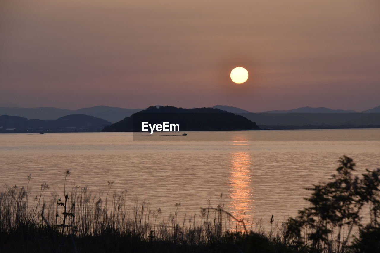 SCENIC VIEW OF LAKE AGAINST ORANGE SKY