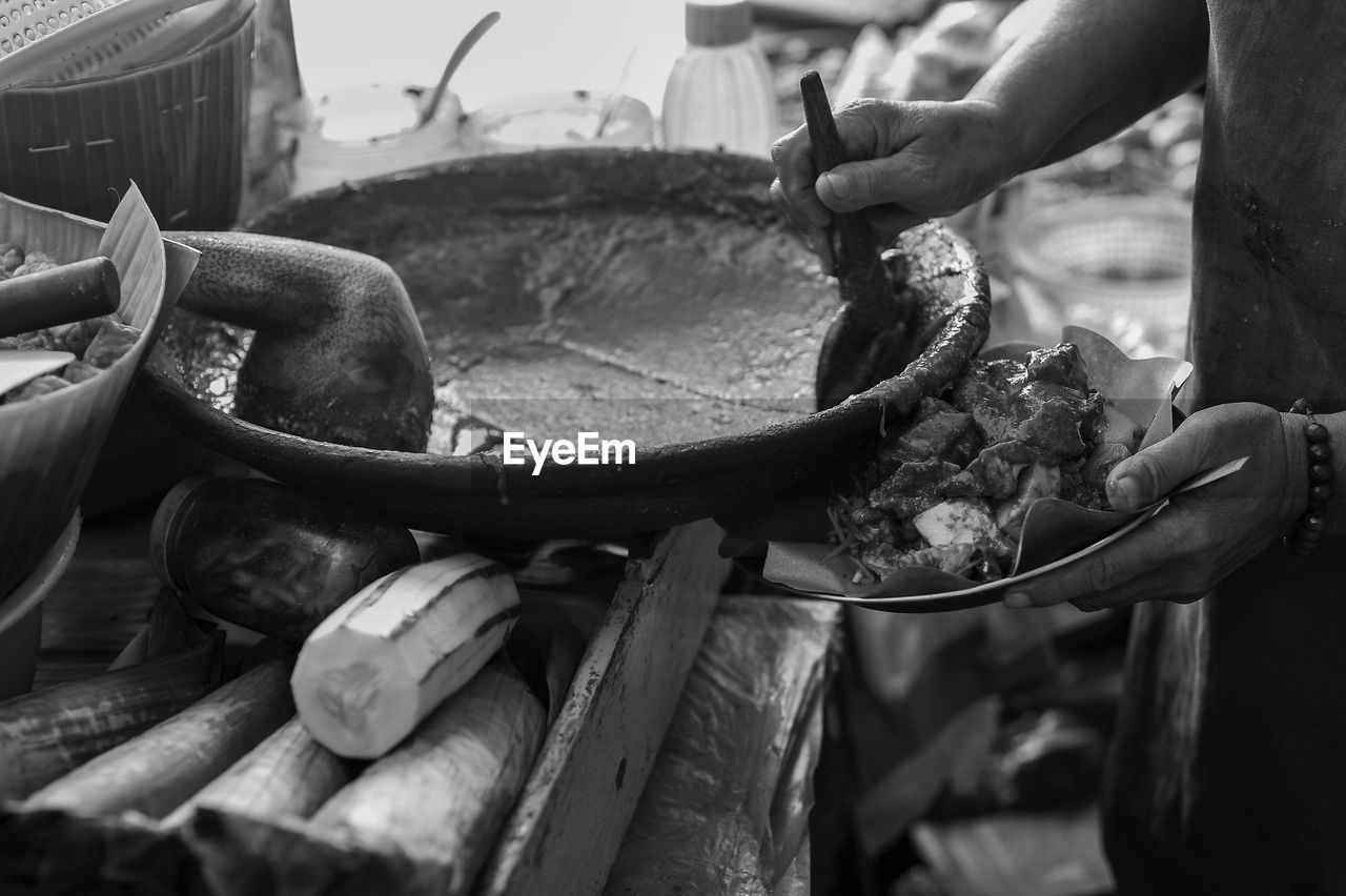 black, black and white, monochrome, food, hand, monochrome photography, one person, occupation, vehicle, food and drink, holding, adult, men, day, freshness, working, focus on foreground, outdoors, wheel, person, animal